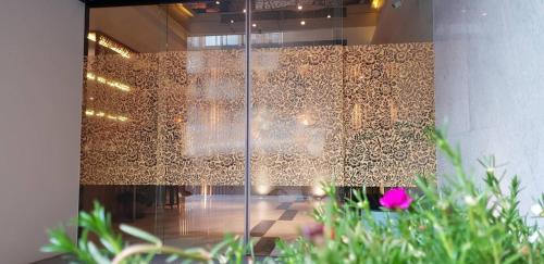 a room with a glass door with a wall with designs at Bizotel Premier Hotel & Residence in Bangkok