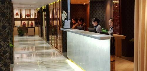 a group of people sitting at a bar in a hotel at Bizotel Premier Hotel & Residence in Bangkok
