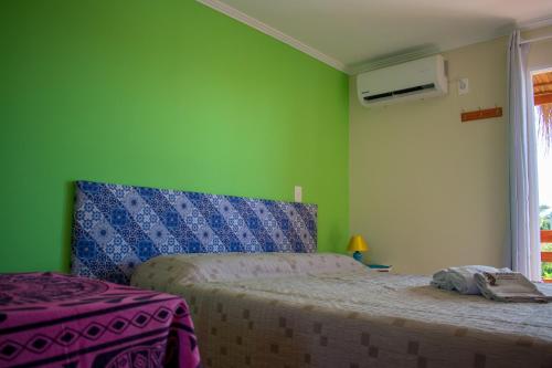 1 dormitorio con cama y pared verde en Aparts Dunas de Valizas, en Barra de Valizas