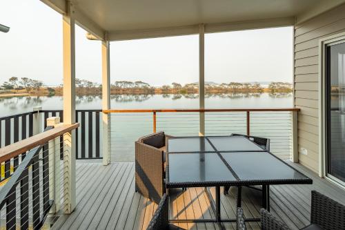 a balcony with a table and a view of the water at Ingenia Holidays White Albatross in Nambucca Heads