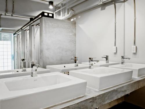 a bathroom with four sinks and a row of mirrors at Loyy Hotel in Chiang Mai