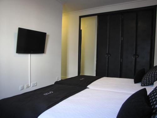 a bedroom with a bed with a television on the wall at Hotel Room in Pontevedra