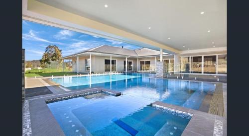 una gran piscina en una casa grande en ON Keppies - BnB - Family Farm & Wedding Guest Accommodation Paterson NSW, en Paterson