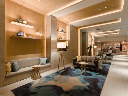 a lobby of a hotel with a couch and tables at Novotel Okinawa Naha in Naha