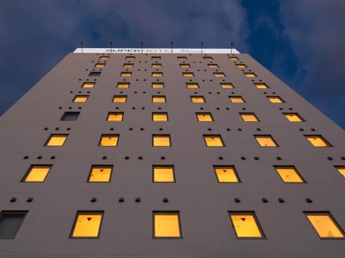 a tall white building with many windows on it at Super Hotel Premier Shimonoseki in Shimonoseki