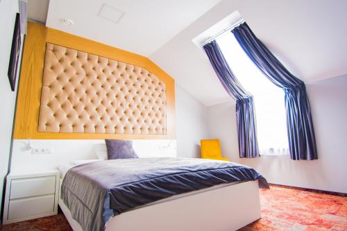 una camera da letto con un letto con una grande testiera di Hotel Sjesta a Nowa Sól