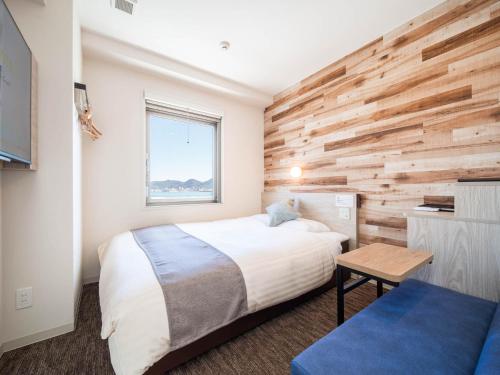 מיטה או מיטות בחדר ב-Super Hotel Premier Shimonoseki