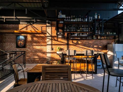 um restaurante com uma parede de tijolos, uma mesa e cadeiras em SuanGlangNa em Phrae