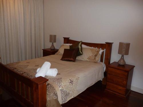 um quarto com uma cama com 2 mesas de cabeceira e 2 candeeiros em City Getaway 3 Bedroom Adelaide's East End em Adelaide