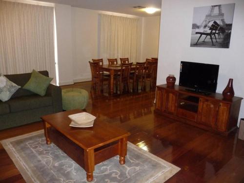 uma sala de estar com um sofá e uma mesa de centro em City Getaway 3 Bedroom Adelaide's East End em Adelaide