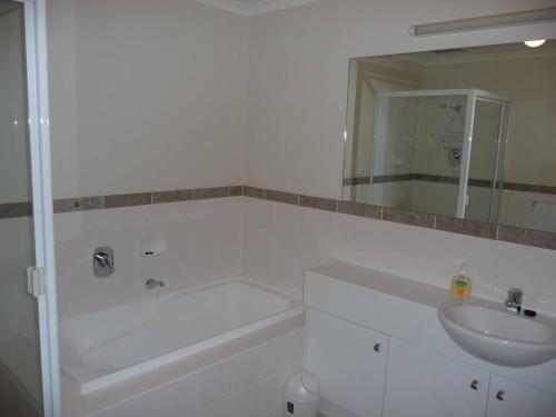 y baño con lavabo, bañera y espejo. en City Getaway 3 Bedroom Adelaide's East End en Adelaida