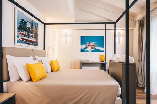 a bedroom with a large bed with yellow pillows at Araba Fenice Hotel in Iseo