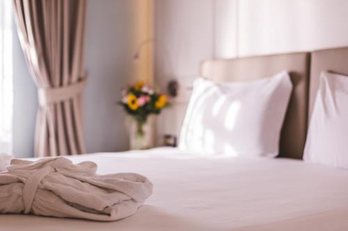 a white bed with a towel on top of it at Araba Fenice Hotel in Iseo