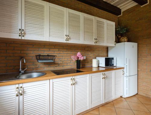 een keuken met witte kasten en een witte koelkast bij 5 stories in Inkartai