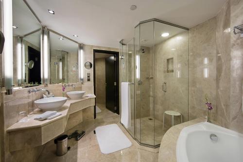 a bathroom with two sinks and a shower at Ramada Plaza by Wyndham Dubai Deira in Dubai