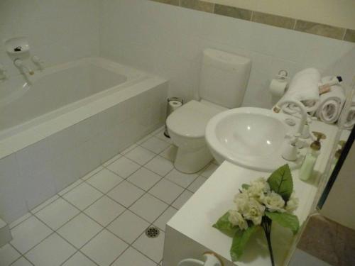 a bathroom with a sink and a toilet and a tub at City Escape 3 Bedroom East End of Adelaide in Adelaide