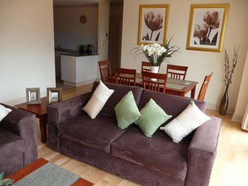 sala de estar con sofá marrón y mesa en City Escape 3 Bedroom East End of Adelaide en Adelaida