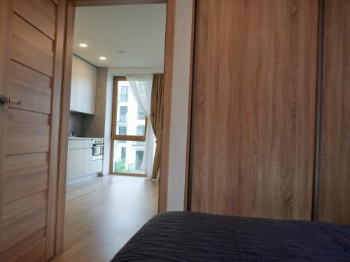 a bedroom with a bed and a wooden door at Elzbietos centro apartamentai in Vilnius