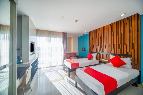 a hotel room with two beds and a television at I Dee Hotel Patong in Patong Beach