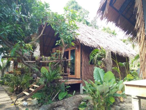a small house with a thatch roof at The Tropical Koh Mook in Koh Mook
