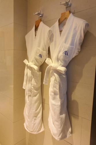 two white shirts are hanging on a wall at Beijing Changbaishan International Hotel in Beijing