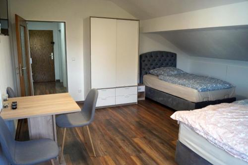 a bedroom with two beds and a table and a desk at OasenEck in Limburg an der Lahn