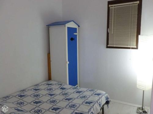 ein Schlafzimmer mit einem Bett und einer blauen Tür in der Unterkunft Coquet appartement in Fleury