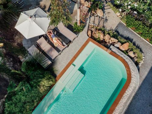 an overhead view of a swimming pool with an umbrella at Roost Glamping - SHA Certified in Rawai Beach