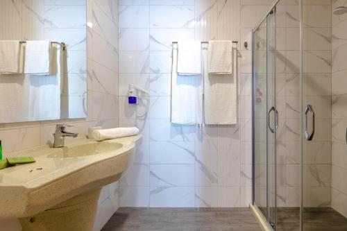 a bathroom with a shower, sink, and toilet at Marina Burgas Hotel in Burgas