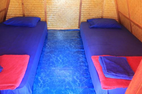two beds in the back of a tent at New Hut Bungalow in Lamai