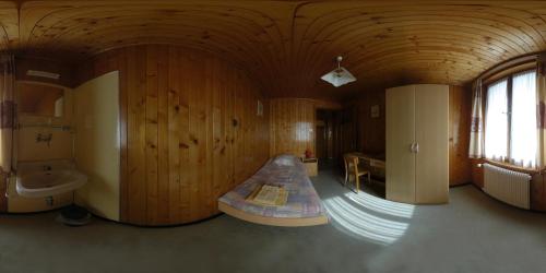 a large room with a bathroom with wooden walls at Hôtel de Torgon in Vionnaz