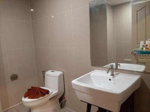 a bathroom with a white toilet and a sink at J.P.GRAND HOTEL in Trat