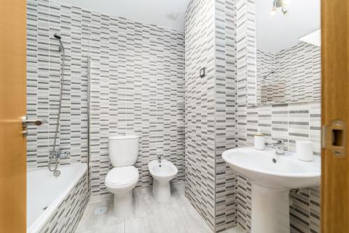マラガにあるMálaga Suite Picassoのバスルーム(トイレ、洗面台、バスタブ付)