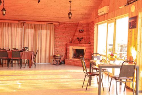 a dining room with a table and a fireplace at Gamarjoba Hotel in Tbilisi City