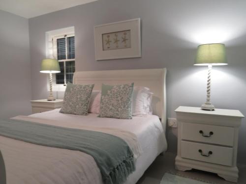 a bedroom with a bed with two lamps on it at Oppidraai B in Paternoster