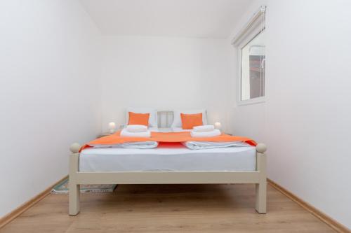 a bedroom with a bed with orange and white sheets at Apartments "Tuffo" in Sarajevo