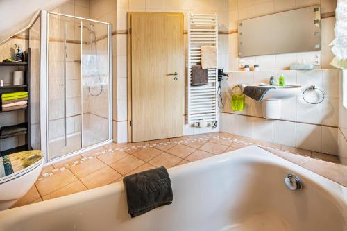 a large bathroom with a tub and a shower at Ferienwohnung Reddemann in Westerstede