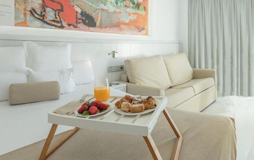 ein Wohnzimmer mit einem Tablett mit Speisen und einem Glas Orangensaft in der Unterkunft Hotel Villa Luz in Gandía