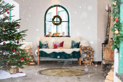 a living room with a christmas tree and a couch at Hotel Zum Stern - Bergbahnen inklusive im Sommer 2025 in Bad Hofgastein