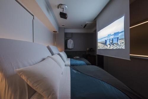 a bedroom with a bed and a tv on the wall at slash kawasaki in Kawasaki