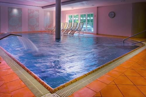 una gran piscina cubierta con una fuente en una habitación en Willa Alexander Resort & SPA - caloroczny BASEN kryty, szybkie Wifi!, en Mielno