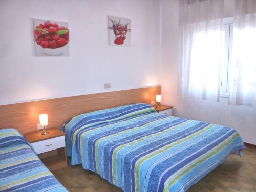 リニャーノ・サッビアドーロにあるBiancaのベッドルーム1室(ストライプのベッドカバー付)