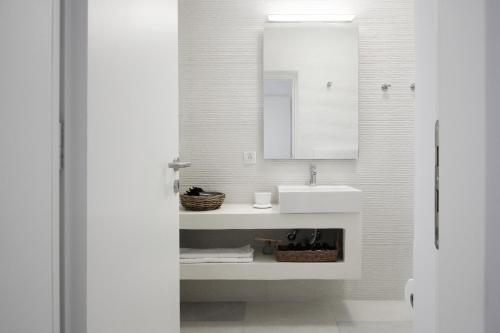 a white bathroom with a sink and a mirror at Villa Orso Blue I in Ioulis