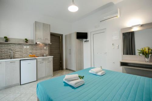 a kitchen with a large blue bed with two towels at Kolimbito Sea Side in Falasarna