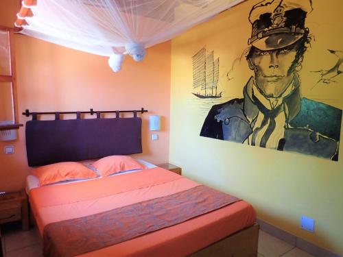 a bedroom with a bed with a painting on the wall at hotel trecicogne in Morondava