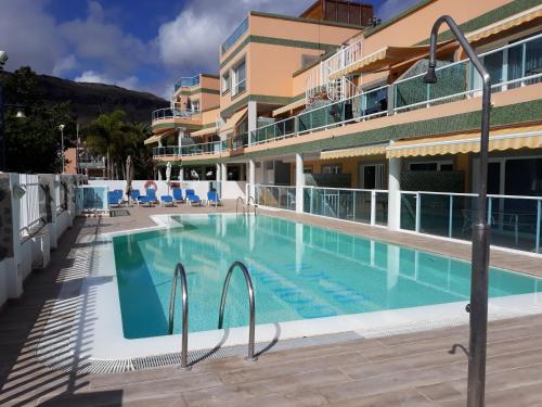 een groot zwembad voor een gebouw bij Playa Mogan Golden Beach 1 by El Sirocco in Puerto de Mogán