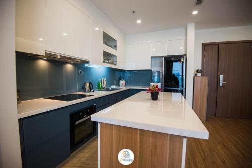 a kitchen with blue and white cabinets and a counter top at Vinhomes Metropolis luxury Hotel & Residence in Hanoi