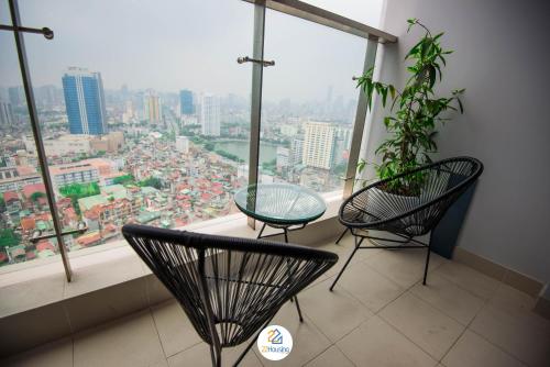 two chairs and a glass table in front of a window at Vinhomes Metropolis luxury Hotel & Residence in Hanoi