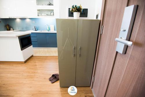 a green cabinet in a kitchen next to a door at Vinhomes Metropolis luxury Hotel & Residence in Hanoi