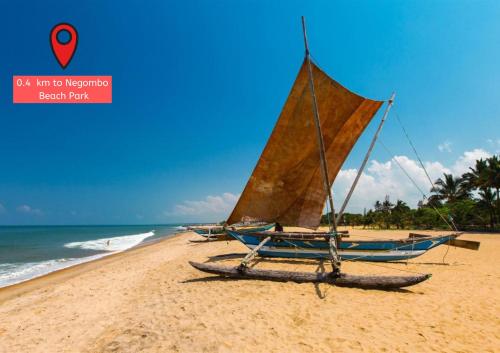 a boat on a sandy beach with the ocean at Holiday Guest Inn in Negombo